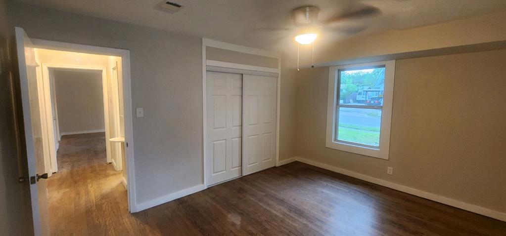 7342 Amy Street Dallas, TX 75217 - Photo 5 of 7 an empty room with wooden floor and windows
