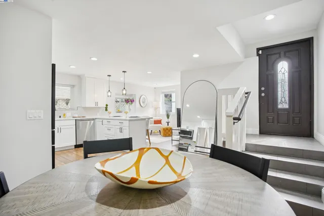 a living room with furniture a mirror and kitchen view