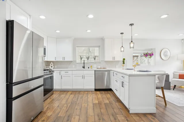 a kitchen with a sink a refrigerator and white cabinets
