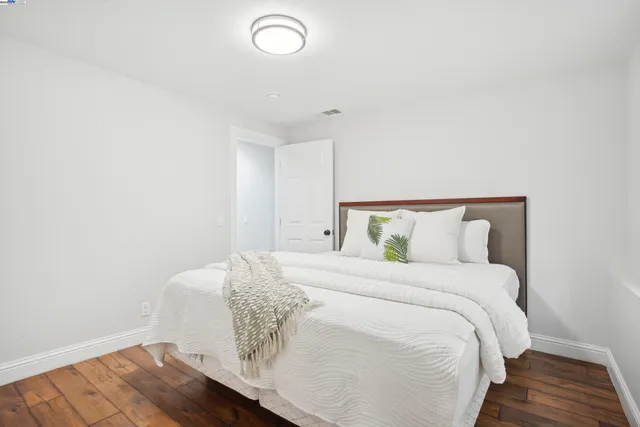 a bedroom with a bed and wooden floor