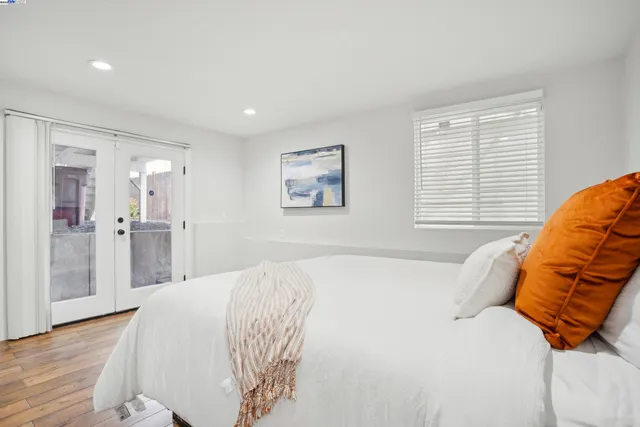 a spacious bedroom with a bed and a painting on the wall