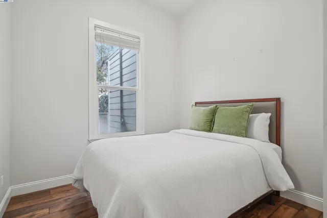 a large bed sitting in a bedroom next to a window