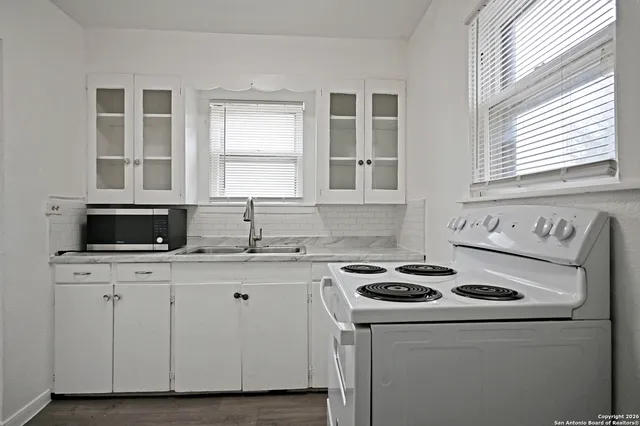 a kitchen with cabinets appliances a sink and a window