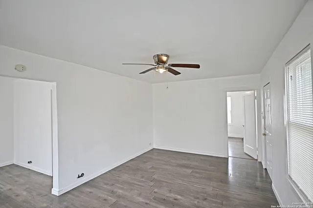 a view of empty room with wooden floor