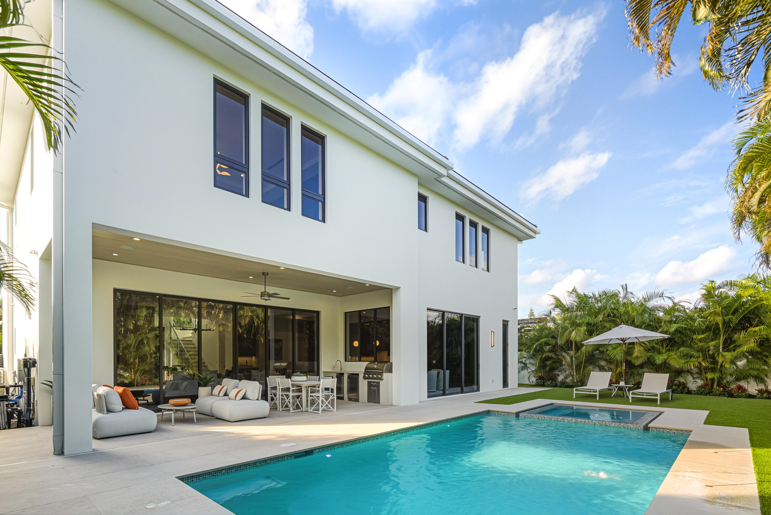 450 Northeast Spanish Court Boca Raton, FL 33432 - Photo 25 of 32 a front view of a house with patio furniture and garden