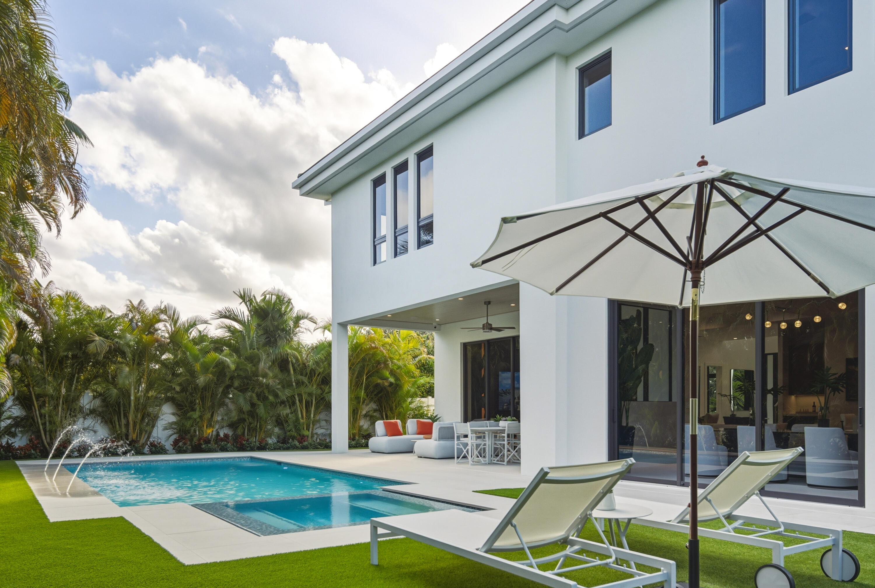 450 Northeast Spanish Court Boca Raton, FL 33432 - Photo 27 of 32 a view of a white house with a yard floor and porch