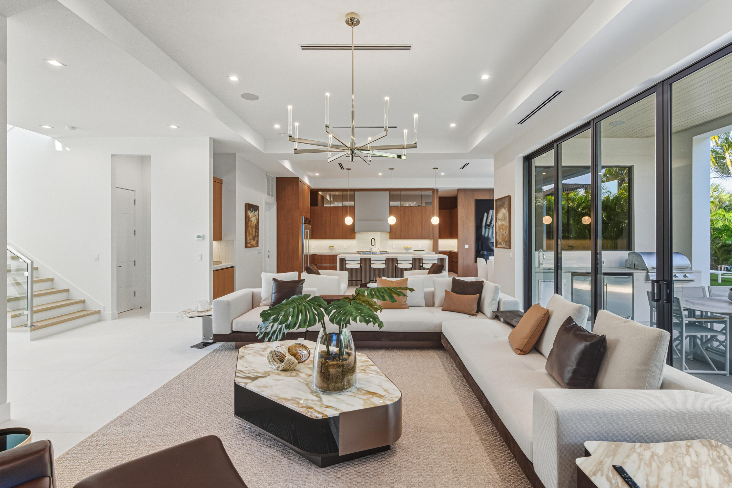 450 Northeast Spanish Court Boca Raton, FL 33432 - Photo 6 of 32 a living room with furniture potted plant and a chandelier