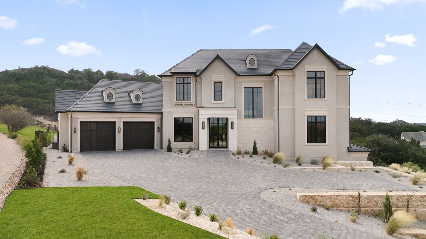 9117 Brookhurst Cove Austin, TX 78733 - Photo 1 of 40 a front view of a house with a yard and garage
