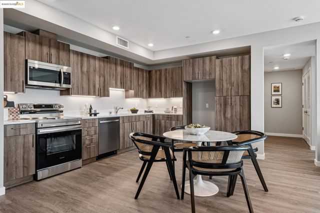 a kitchen with a table chairs refrigerator and cabinets