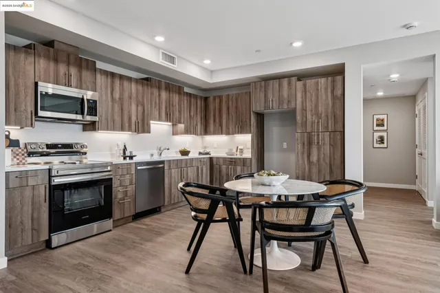 a kitchen with a table chairs refrigerator and cabinets