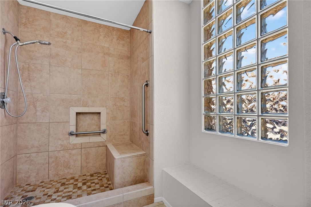 2241 Highpointe Drive, Unit 101 Laughlin, NV 89029 - Photo 22 of 23 This bathroom features a shower with convenient built-in seating and a large glass block window.