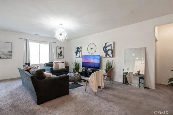a living room with furniture and a chandelier