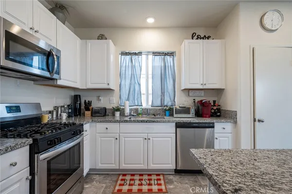 a kitchen with stainless steel appliances granite countertop a stove and a microwave