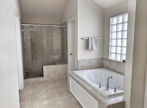 a bathroom with a tub shower and sink