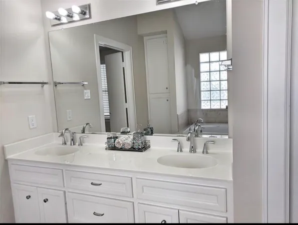 a bathroom with double vanity sinks and a mirror