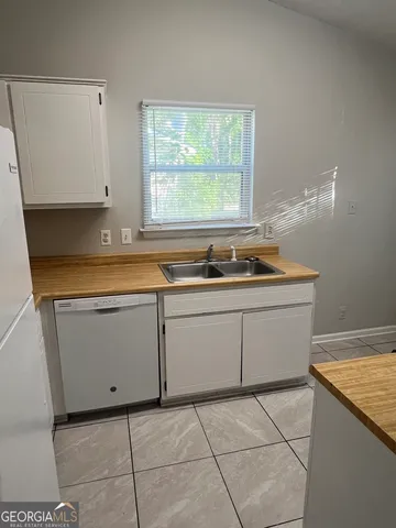 a kitchen with a sink a stove and cabinets