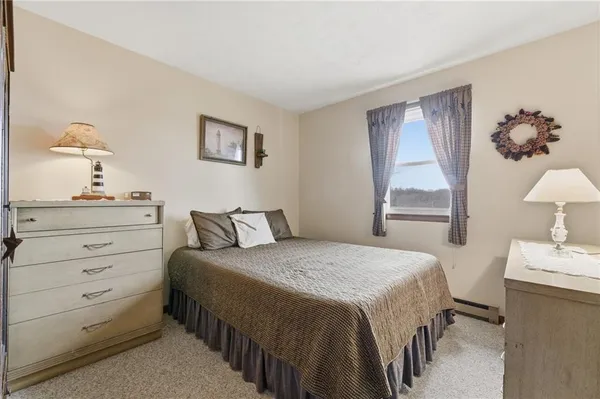 a bedroom with a bed and dresser with mirror