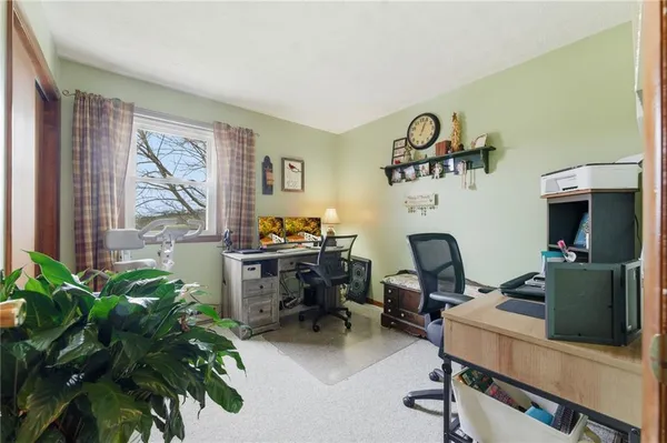 a view of a workspace with furniture and a window