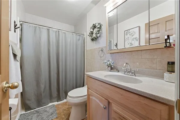 a bathroom with a sink a toilet and shower curtain