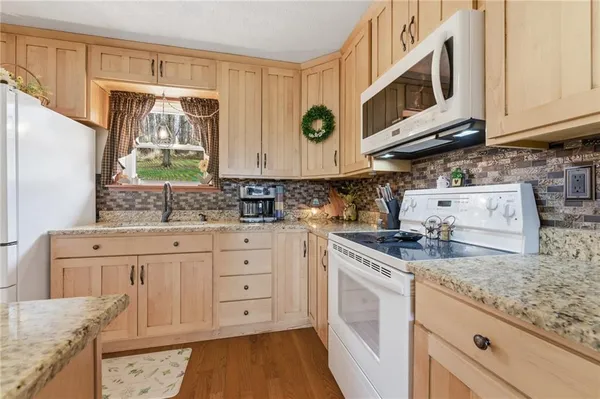 a kitchen with stainless steel appliances granite countertop a sink and a stove