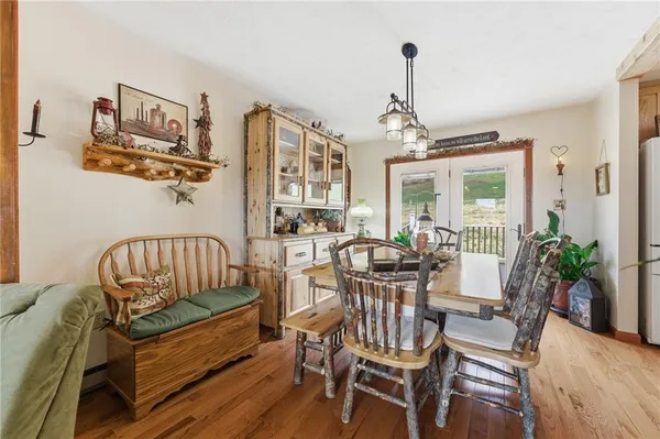 a dining room with furniture a chandelier and wooden floor