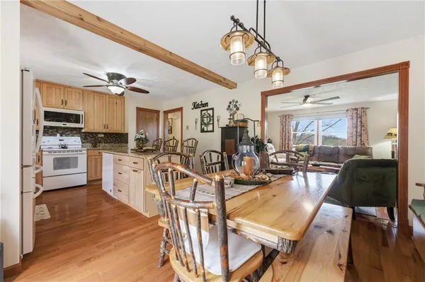 a view of a dining room and livingroom with furniture wooden floor a chandelier