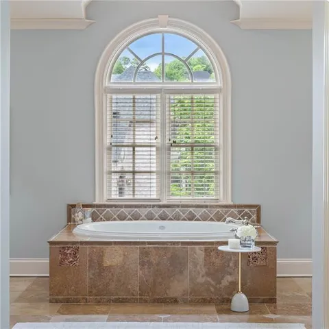 a spacious bathroom with a tub a window and a shower