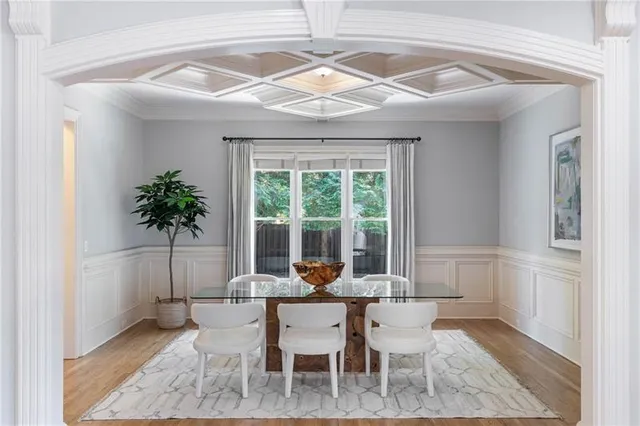 a living room with couches chairs and kitchen view with wooden floor