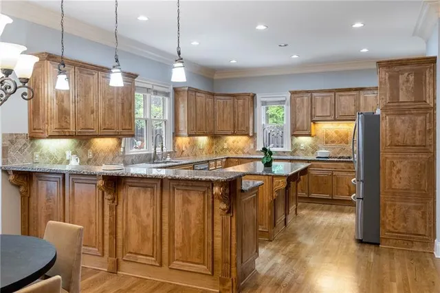 a kitchen with granite countertop a sink and a refrigerator