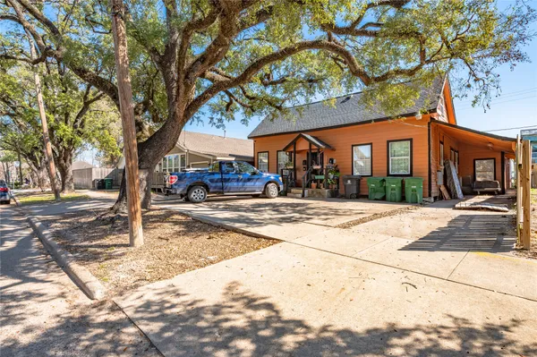 a view of a pathway of a house with backyard and wooden fence