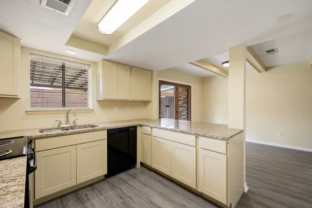 a bathroom with a granite countertop sink and white cabinets