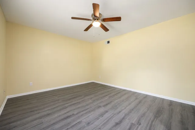 a view of room with wooden floor and ceiling fan