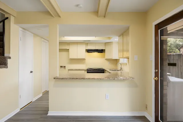 a kitchen with a sink cabinets wooden floor and stainless steel appliances