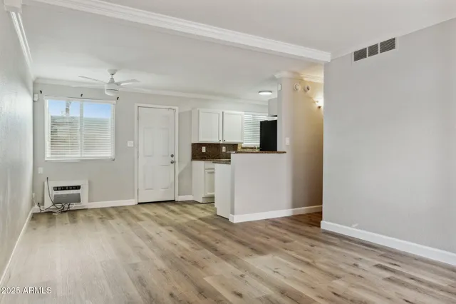 a view of empty room with wooden floor and window