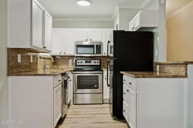 a kitchen with stainless steel appliances granite countertop a refrigerator stove and microwave
