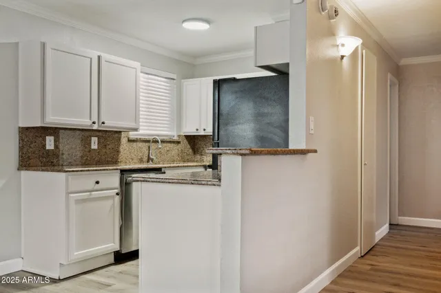 a kitchen with stainless steel appliances granite countertop a sink and a stove with white countertops