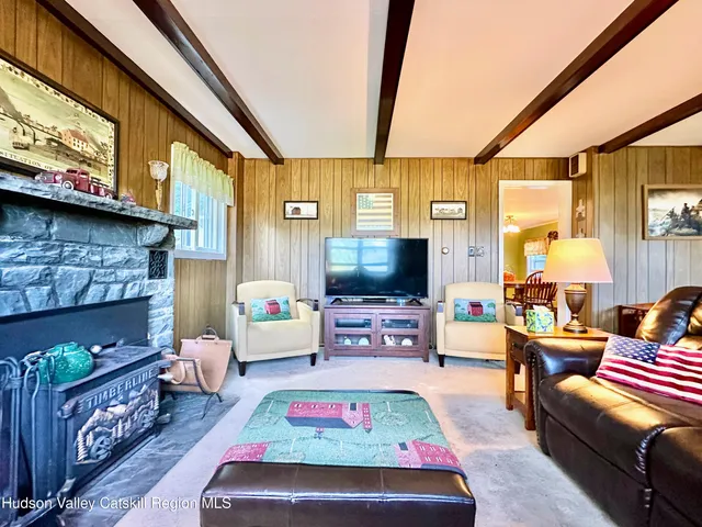 a living room with furniture a fireplace and a large window