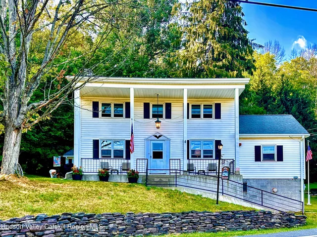 a view of swimming pool with lawn chairs and plants