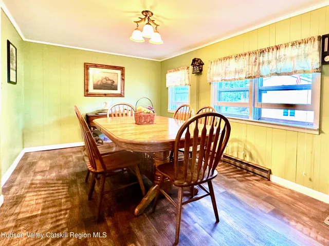 a dining room with furniture a flat screen tv and wooden floor