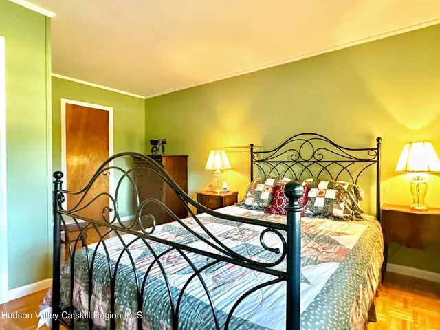 a bedroom with a bed and a lamp on dresser