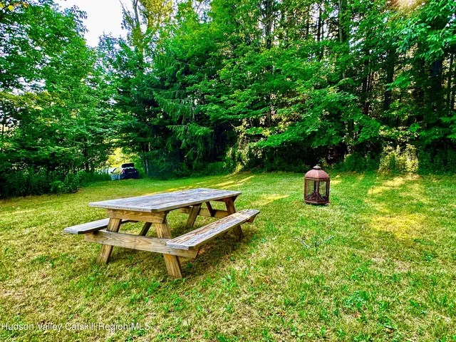 a view of a swimming pool with a patio and a yard