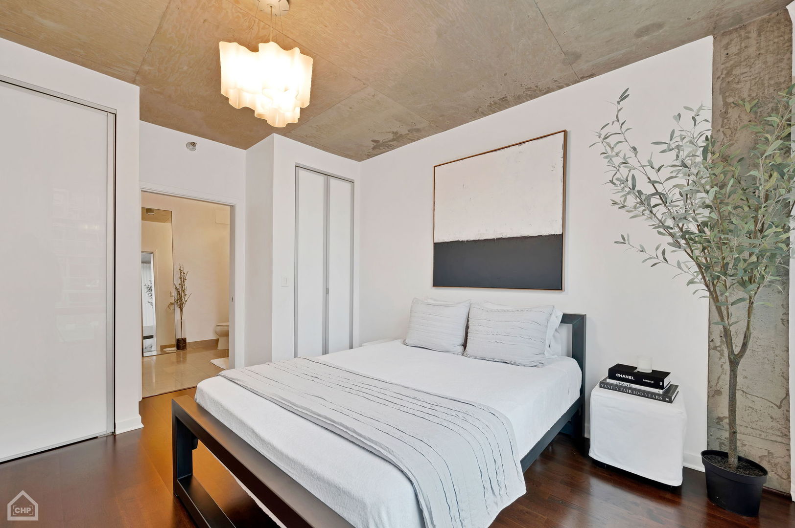 611 South Wells Street, Unit 904 Chicago, IL 60607 - Photo 5 of 17 a bedroom with a bed and a chandelier
