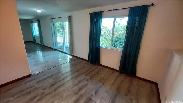 a view of hallway with a window and wooden floor