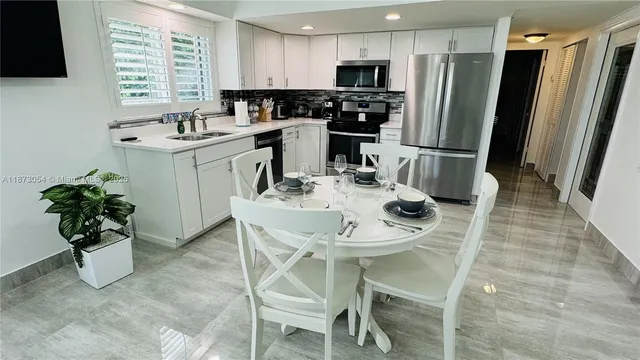 a kitchen with stainless steel appliances kitchen island granite countertop a sink refrigerator and microwave