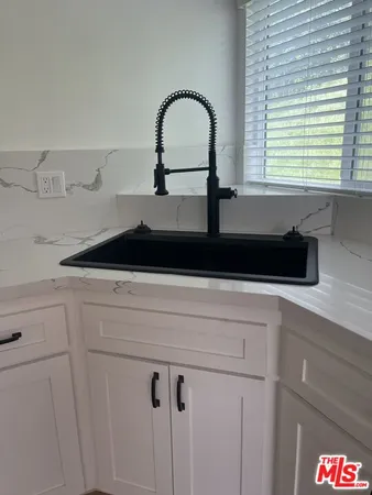 a close view of a sink and dishwasher with kitchen island