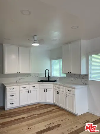 a kitchen with granite countertop a sink and cabinets