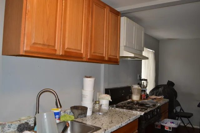 a bathroom with a granite countertop sink and a toilet