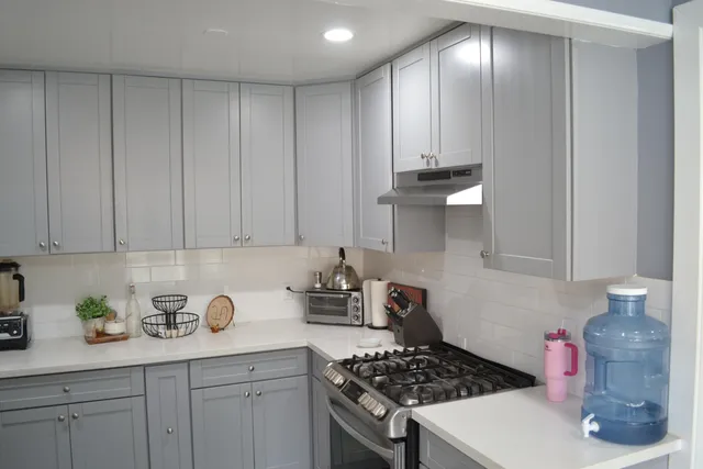 a kitchen with white cabinets and white appliances