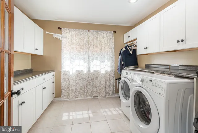 a utility room with cabinets washer and dryer