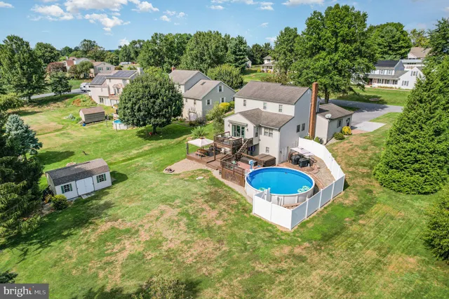 an aerial view of a house with outdoor space pool seating area and yard